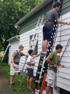 volunteers painting a house